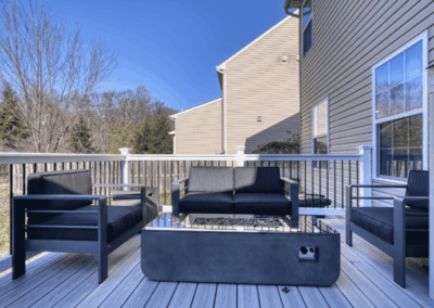 Backyard deck with black furniture and gas fire pit