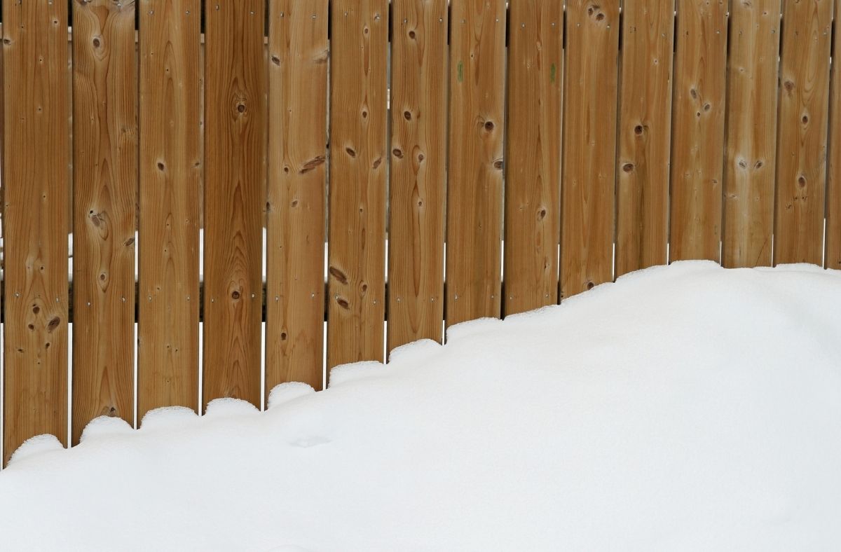Wood fence covered in winter snow