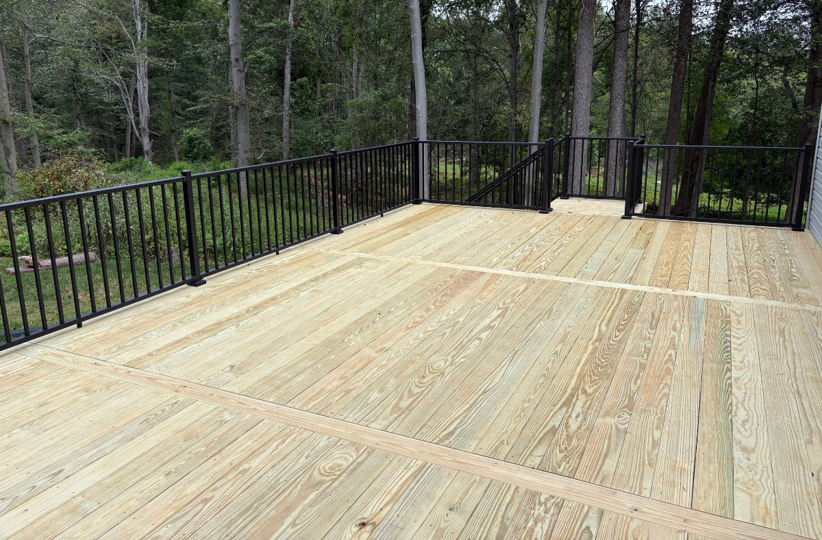Deck with light wood surface and metal handrails