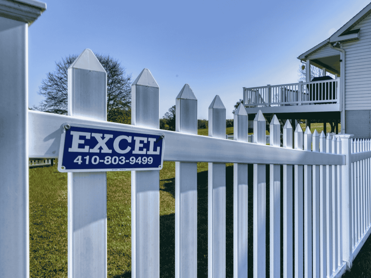 blue excel sign on a white picket fence